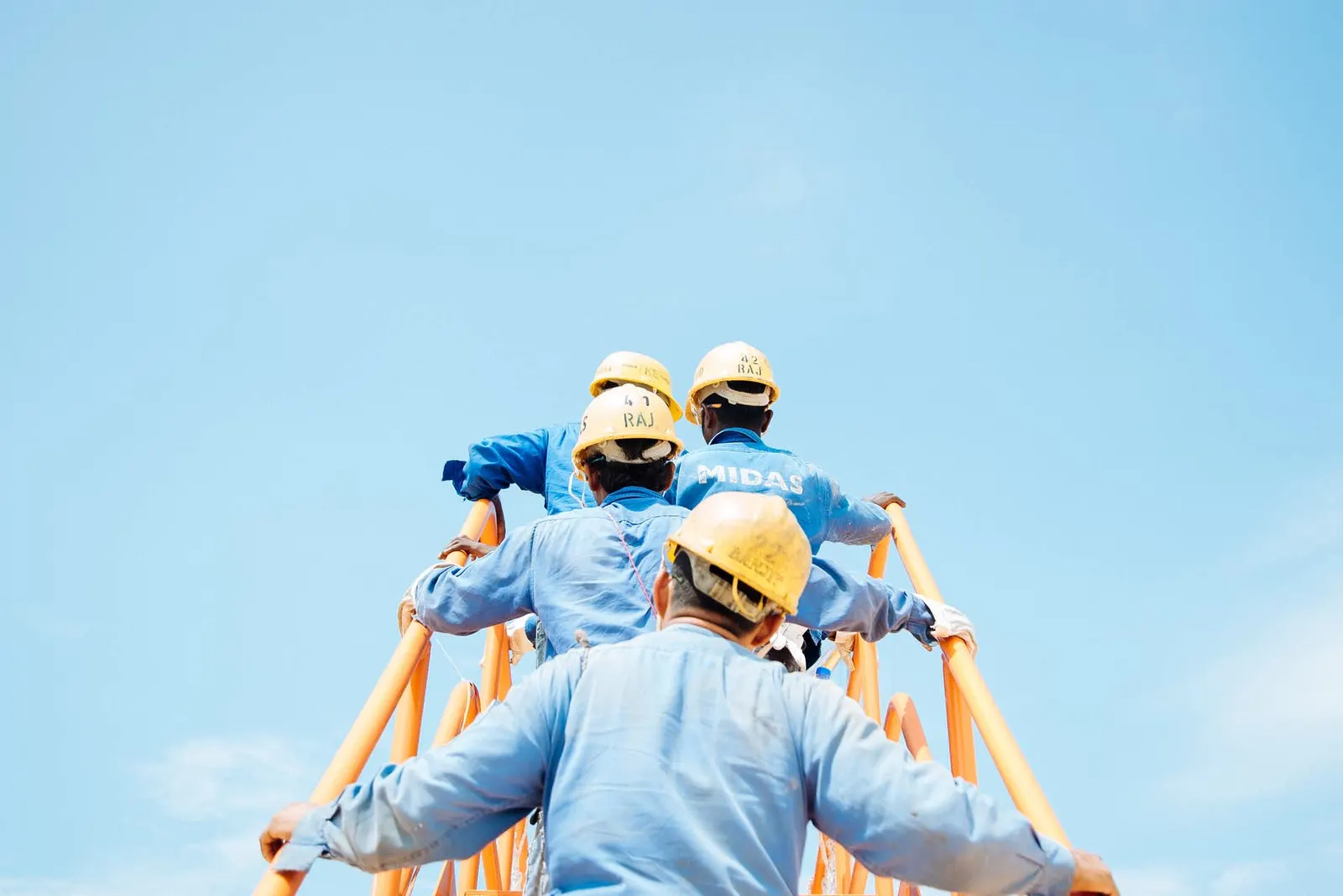 Arbeiter mit Schutzhelmen blicken nach oben